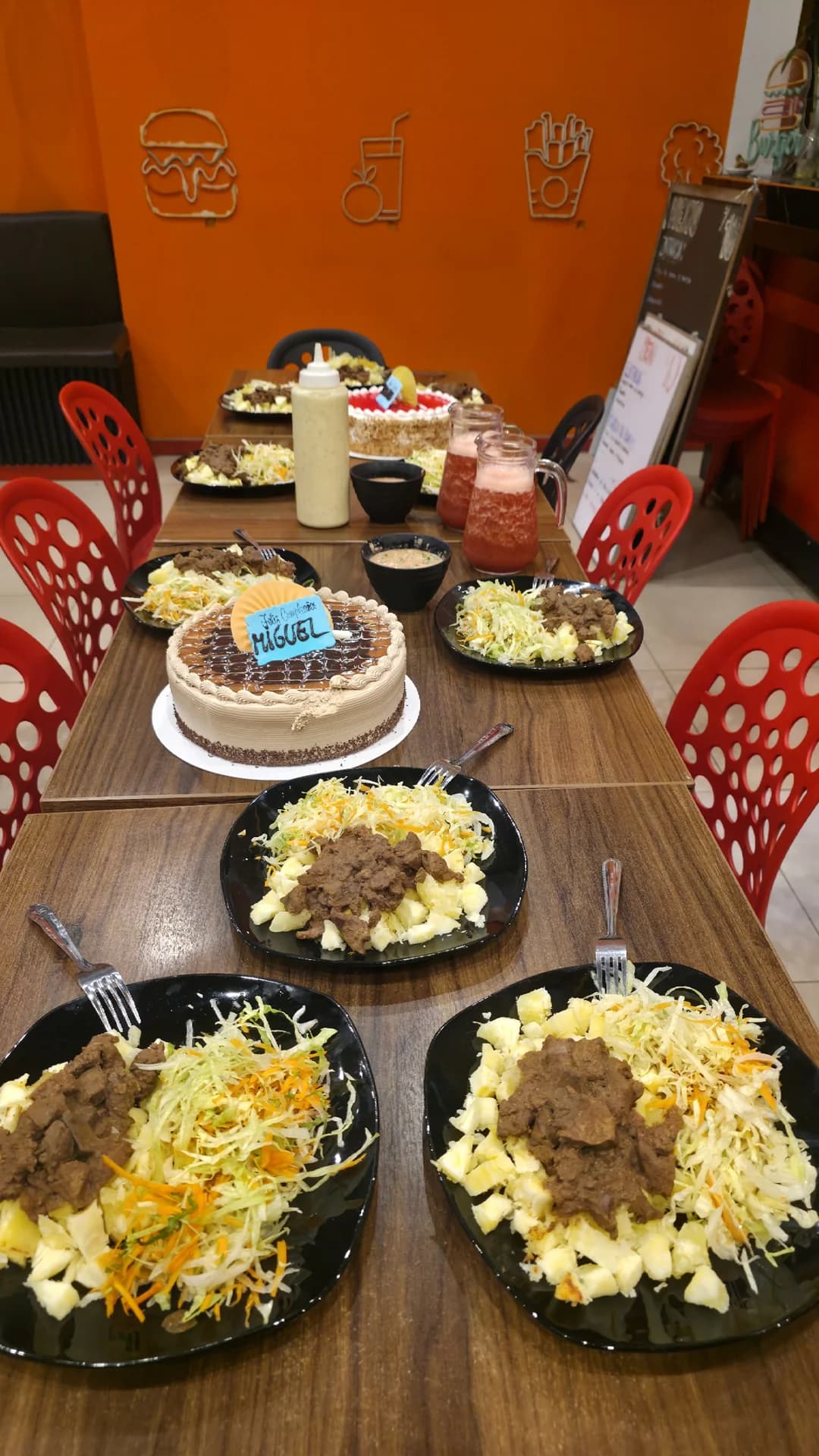 Mesa servida con platos, torta y bebidas para celebración familiar