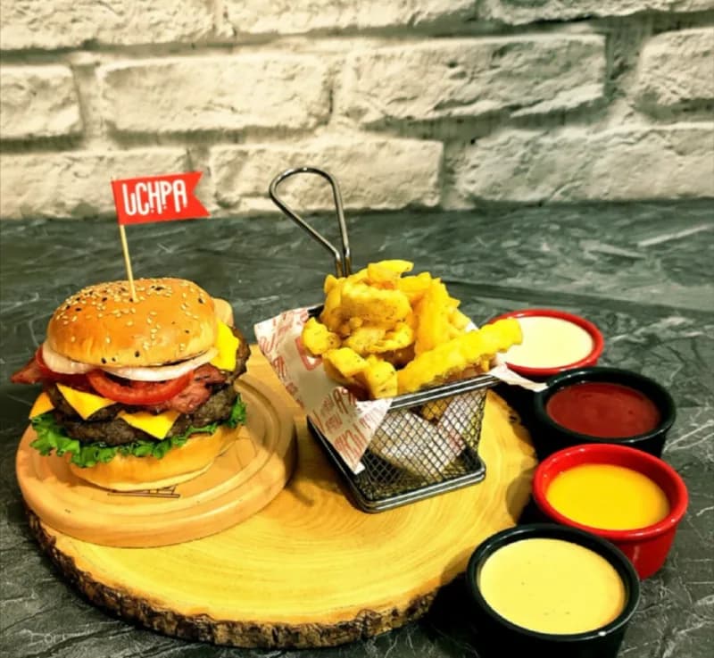 Hamburguesa artesanal UCHPA con papas fritas y salsas en Collique, Comas